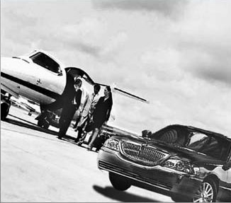 Private jet with limousine on runway.