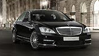Black luxury car parked in urban setting.